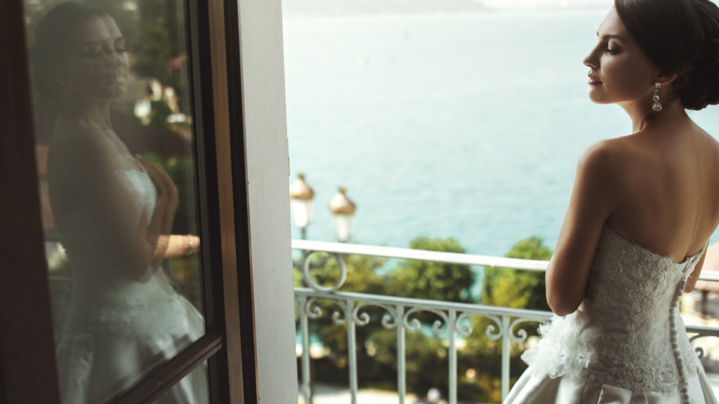Young bride standing on the balcony with ocean view